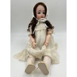 A Simon & Halbig Bisque Porcelain headed doll (57cm) stamp to the neck, with mechanical blue eyes,