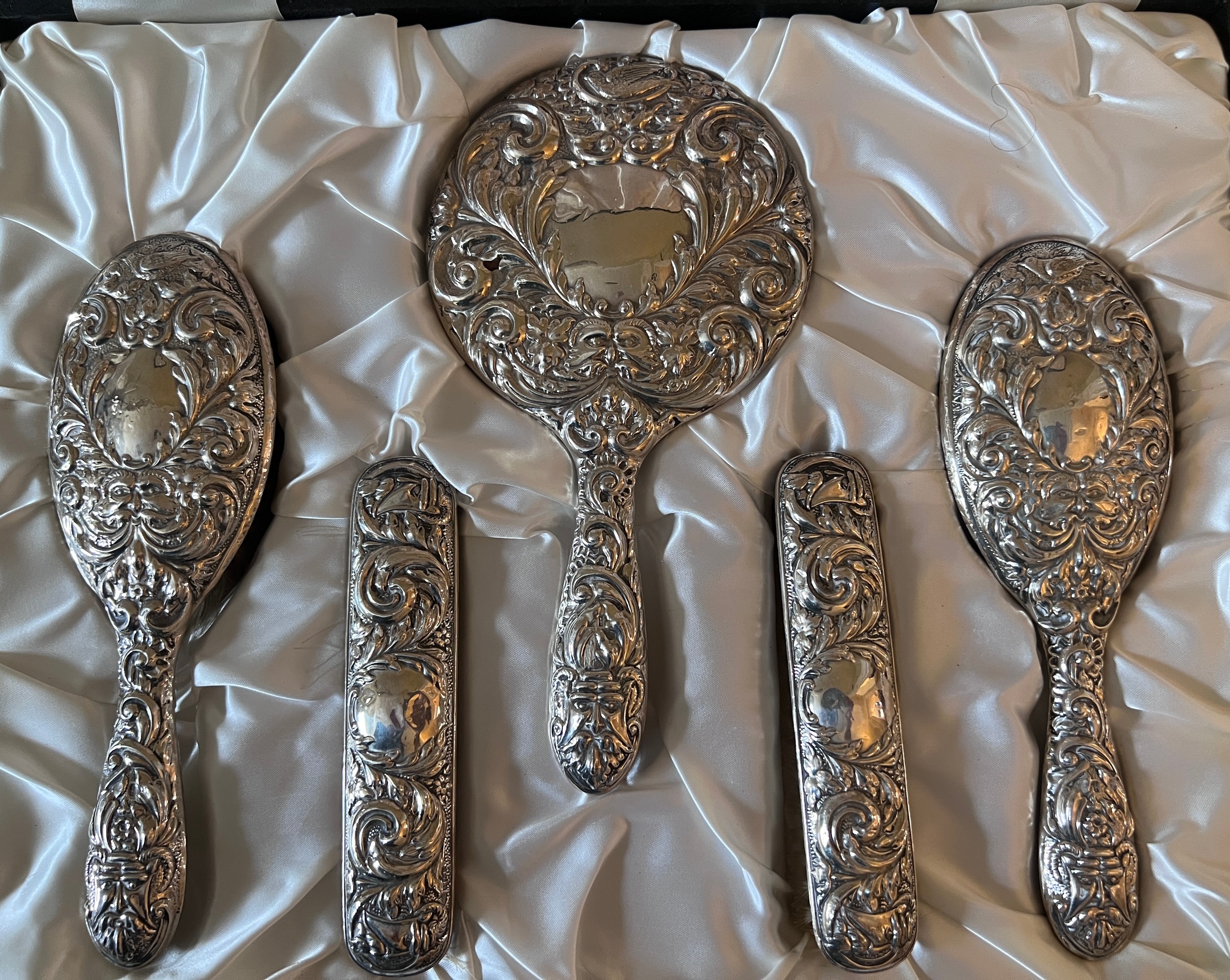 A 20thC cased hallmarked silver backed dressing table set comprising two hairbrushes, two clothes