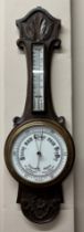 A 20thC oak carved hall mercury barometer with ceramic dial, 81cm h x 26cm at widest point.