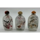 Set of three Oriental scent/snuff bottles reverse hand painted measuring 8cm. In boxes.