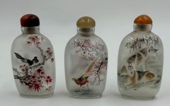 Set of three Oriental scent/snuff bottles reverse hand painted measuring 8cm. In boxes.