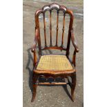 A 19thC cane seated armchair with front cabriole legs and scroll arms. 108cm to back, 43cm to seat.