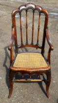 A 19thC cane seated armchair with front cabriole legs and scroll arms. 108cm to back, 43cm to seat.
