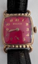 A 1952 gold plated manual dark red Bulova enamelled dial. With guarantee and Bulova case. Good