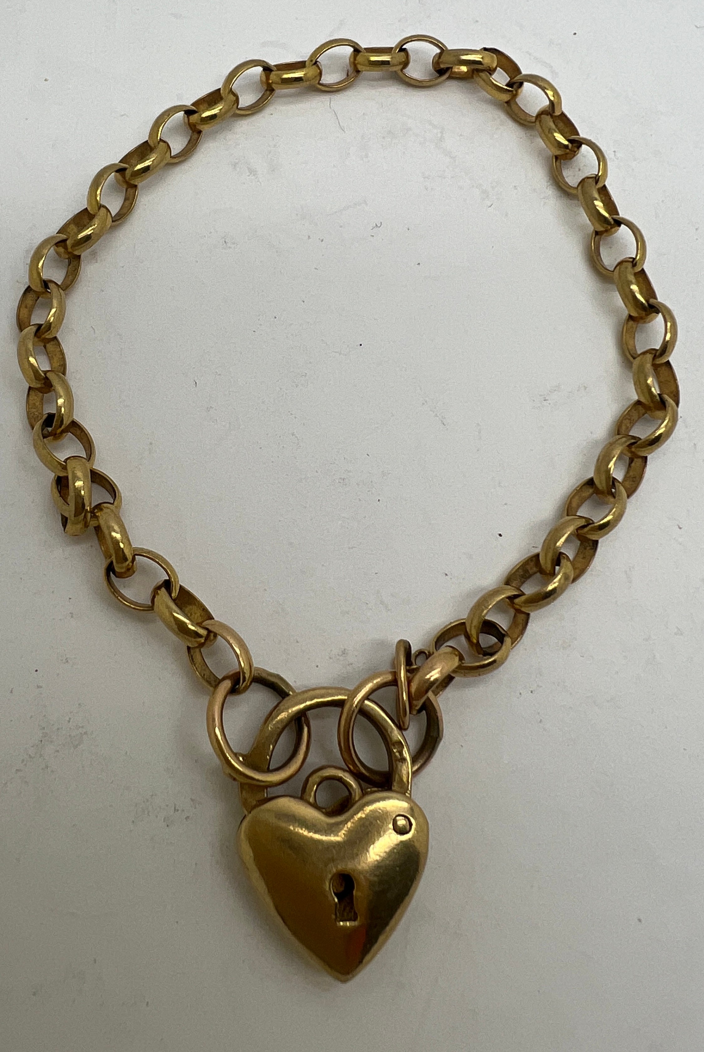 A yellow metal chain bracelet with heart shaped fastening marked 9 carat. Weight 9gm.