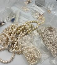 A quantity of cultured and faux pearl necklaces, two with 9 carat gold clasps. One triple strand