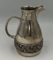 A hallmarked silver jug with acorn and leaf decorative band to base. London 1978, maker House of