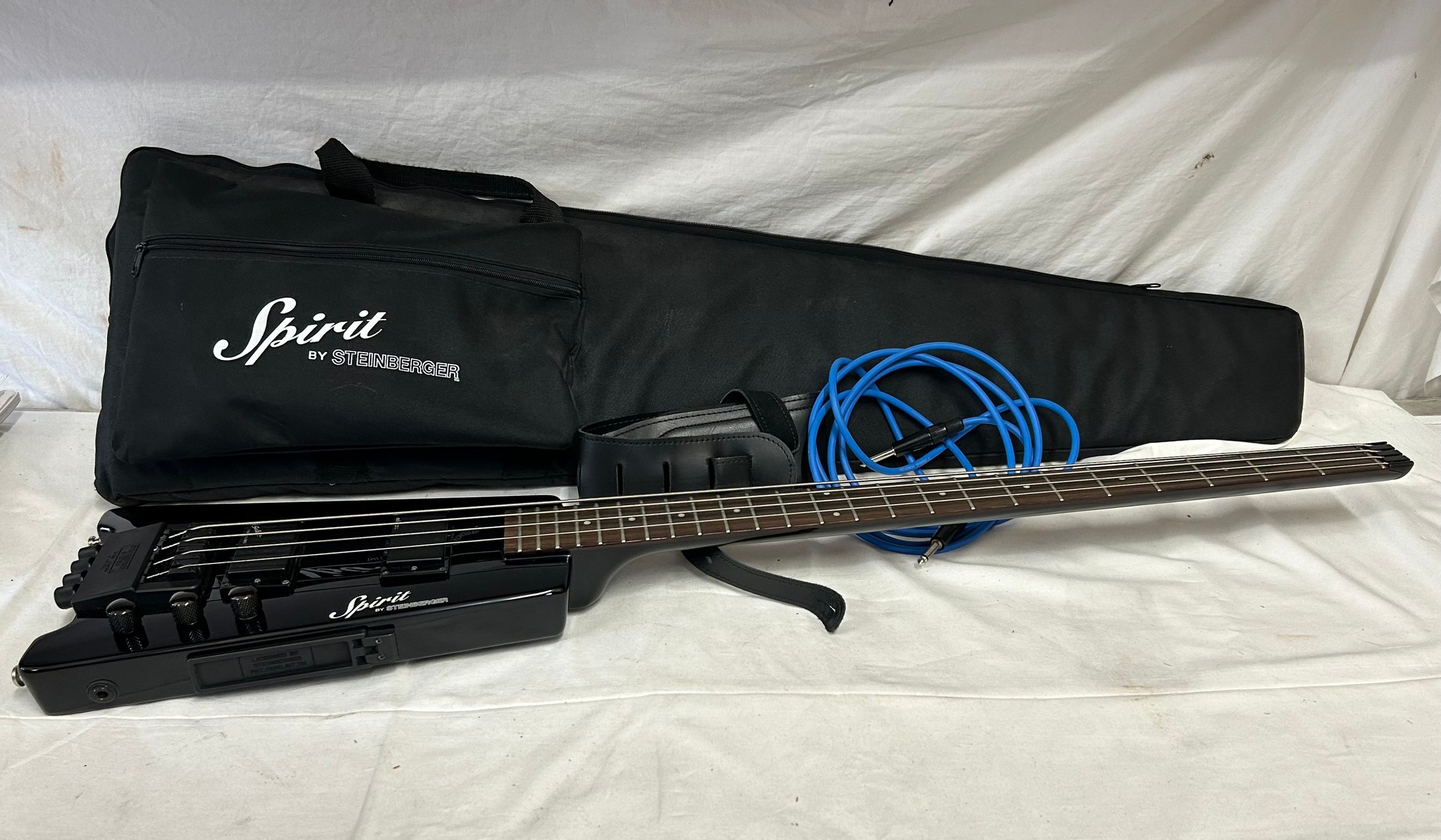 Spirit by Steinberger headless electric guitar with black finish and soft case.