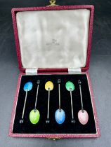 A boxed set of six harlequin guilloche enamel and silver coffee spoons, with bean terminal,