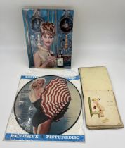A Marilyn Monroe LP picture disc, an early 20thC autograph book and a Martell advertisement.