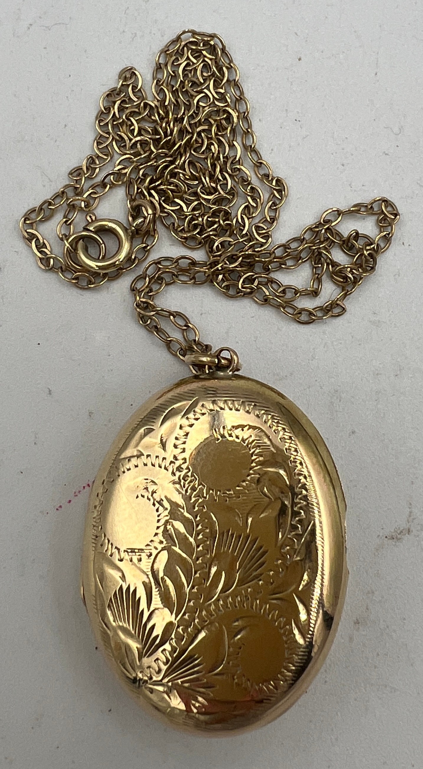 A nine carat gold oval etched locket on a fine nine carat gold chain. Total weight 7.5gm. Length