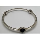 A Georg Jensen sterling silver sphere bangle 473 set with black onyx. Interior measurement 6.5gm.