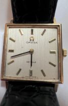 A 9ct gold gentleman's Omega De Ville wristwatch on black leather strap and cream coloured square