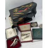 A miscellaneous lot to include grand piano black lacquer music box, crowns, silver identity