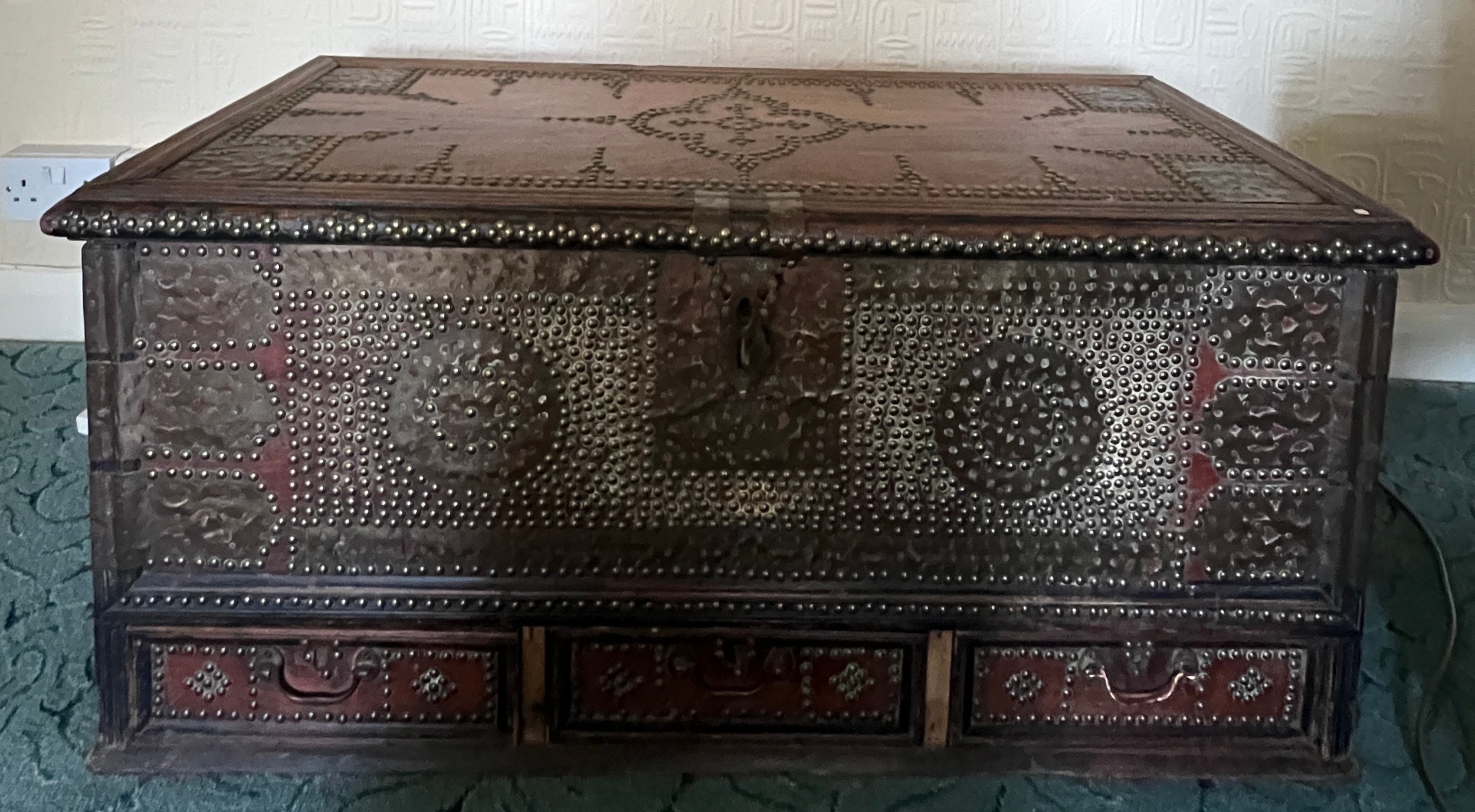 A 19thC Middle Eastern brass studded blanket box with interior candle box and three drawers to base.