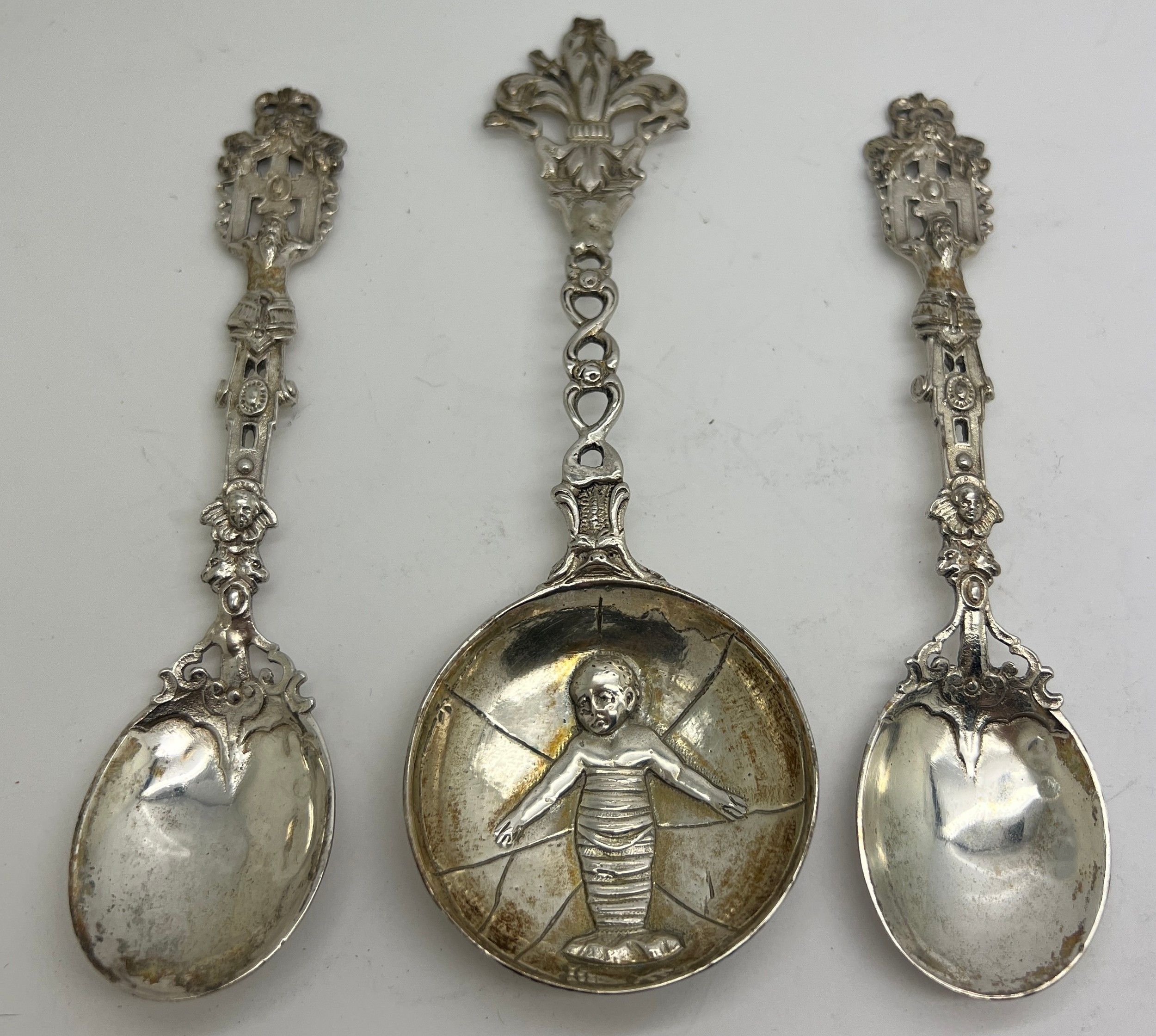 Three decorative spoons, two silver with import marks London 1883 CG and an unmarked white metal