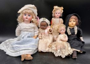 Five various dolls to include four bisque dolls, one with crossed swords to back of head, blonde