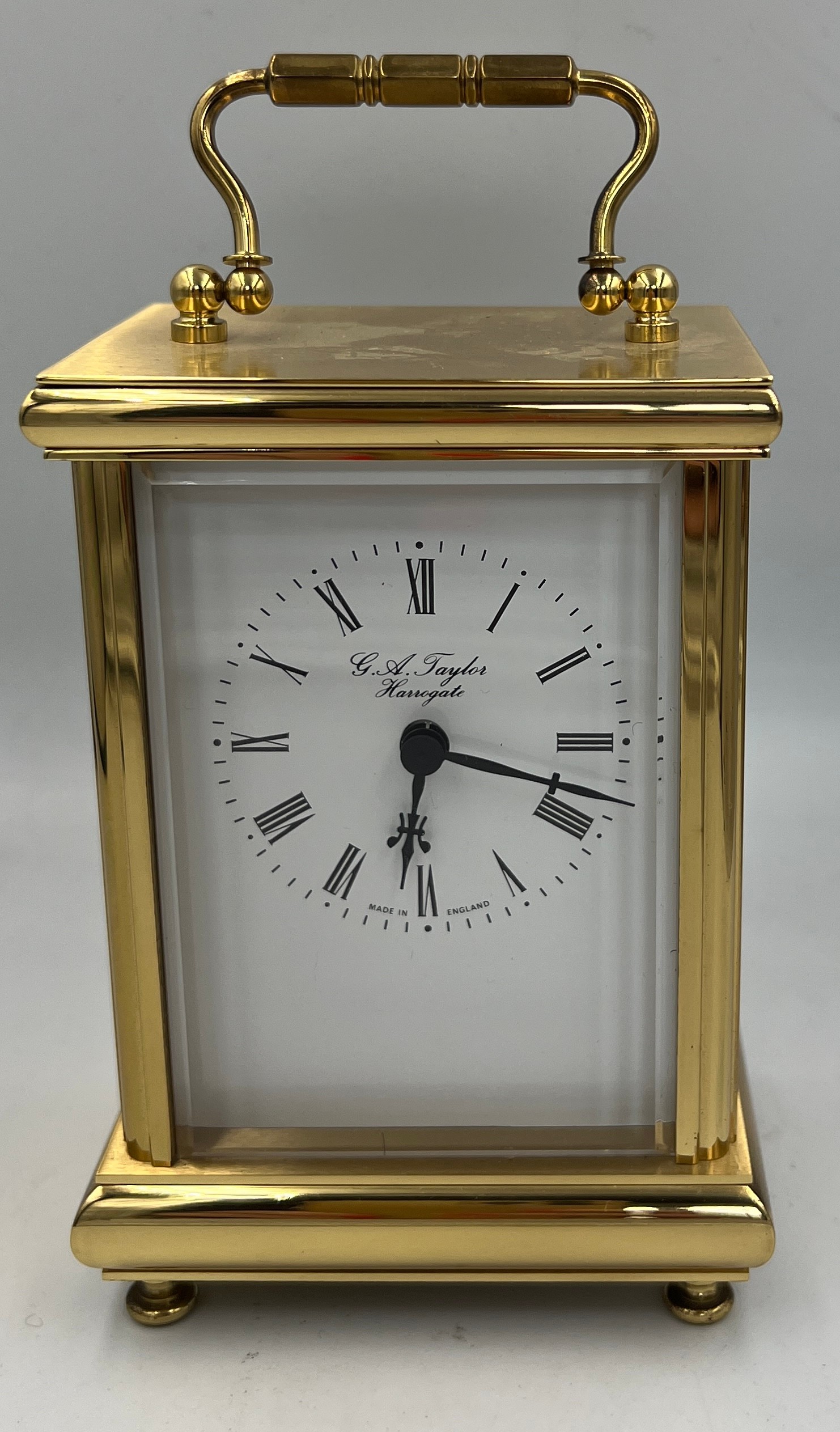 A battery driven brass cased carriage clock, marked to face G.A. Taylor Harrogate.