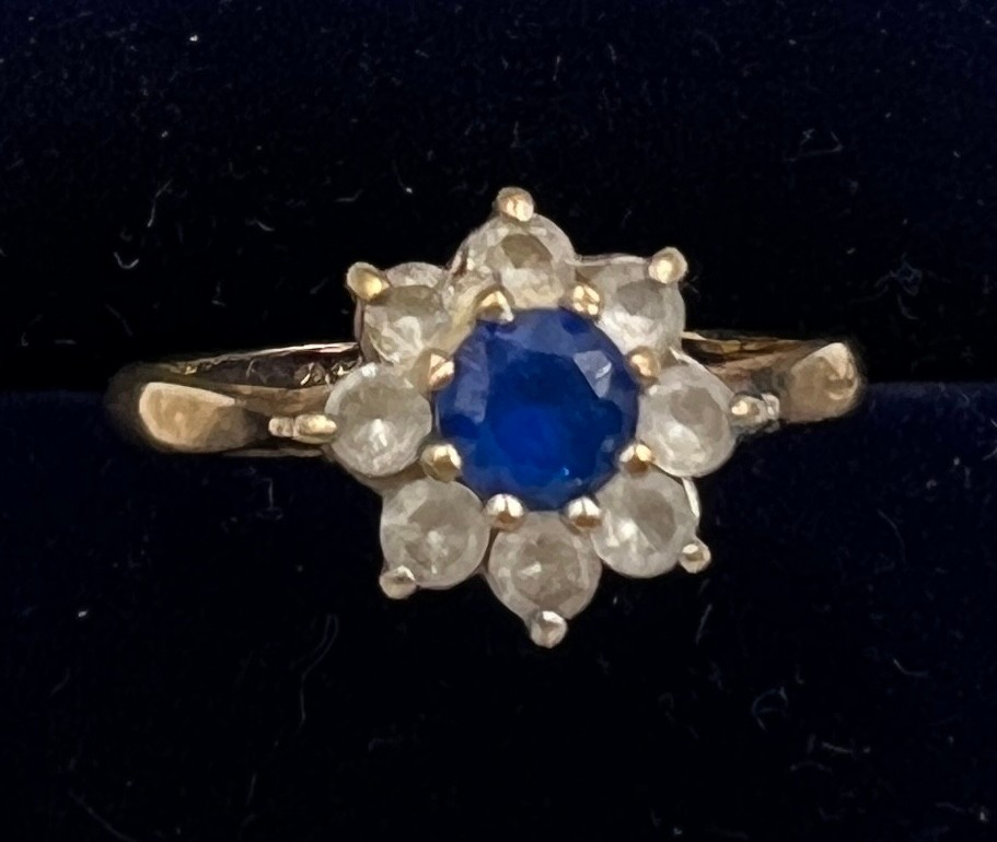 A 9 carat gold ring set with blue and clear paste stones. Size K. Weight 1.8gm.
