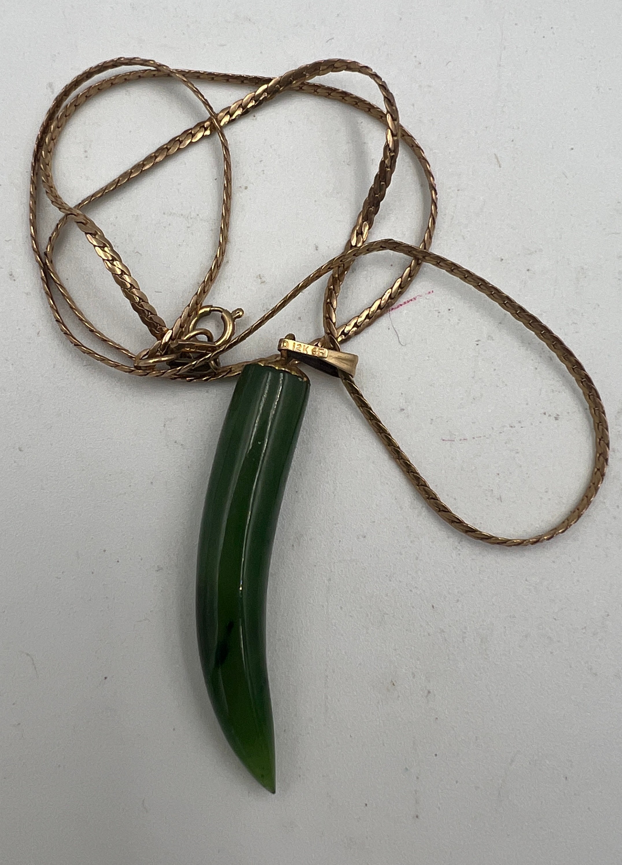 A nine carat yellow gold chain with jade pendant mounted on gold plated ring. Length of chain