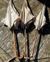 Three Victorian bamboo parasols to include one with embroidered fabric and a carved swan handle
