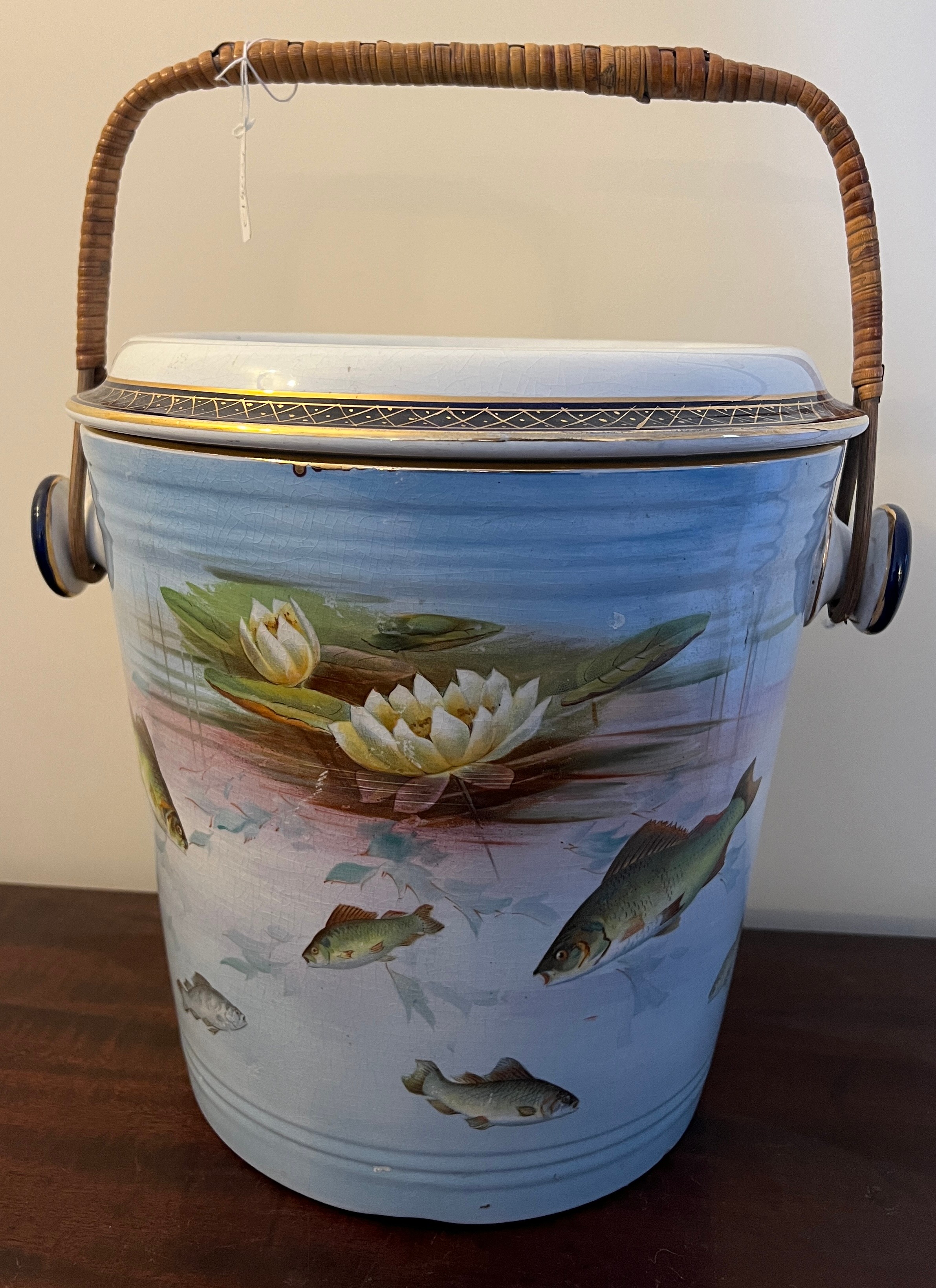 A Winton Grimwades transfer printed slop bucket with fish and waterlily design with wicker handle.