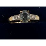 A 9 carat gold ring set with blue and clear stones. Size O. Weight 2.7gm.