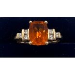 A 9 carat gold ring set with orange and clear stones. Size Q. Weight 3.3gm.