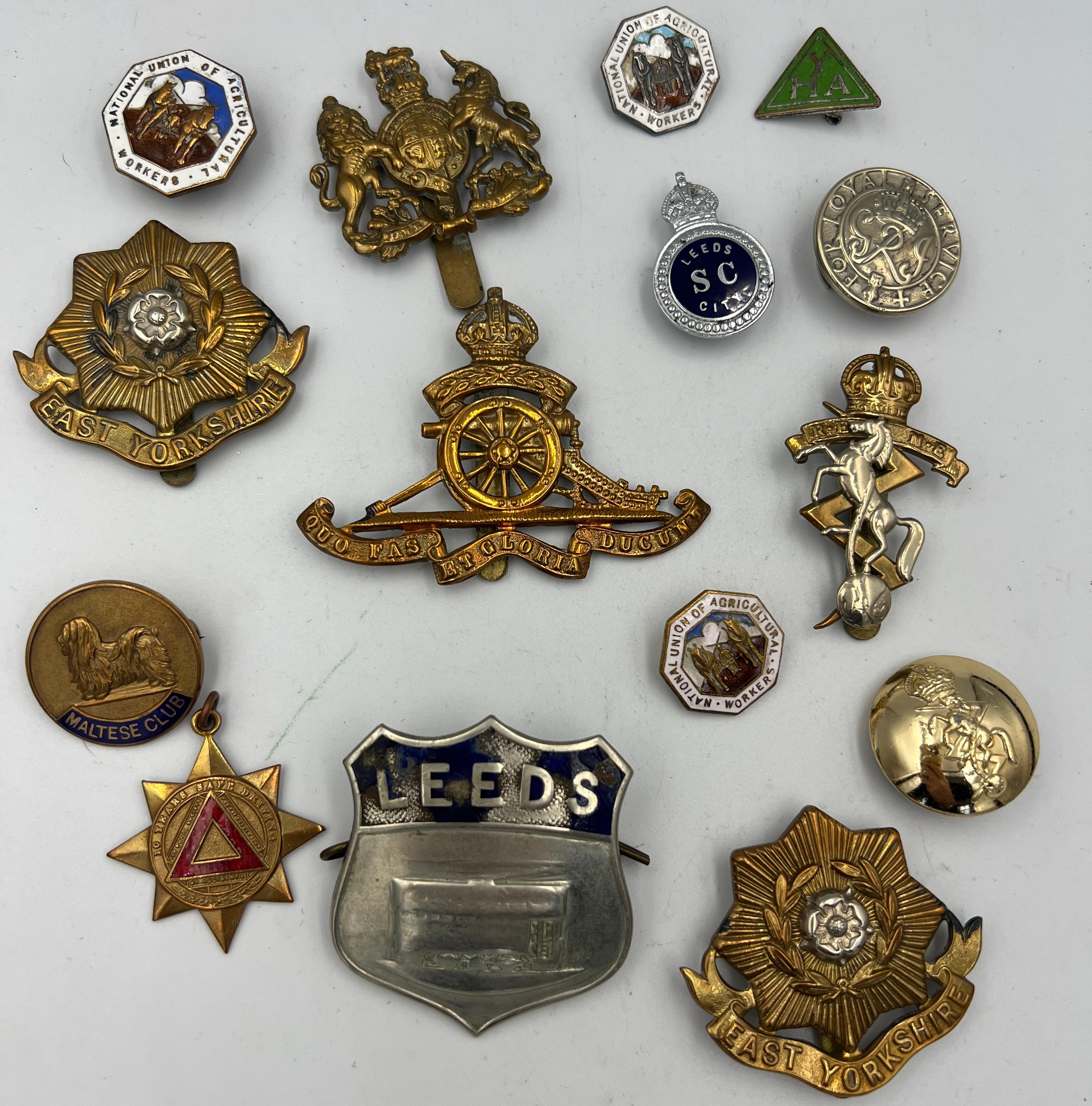 A collection of cap badges etc to include East Yorkshire, Leeds, Maltese club.