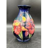 A Moorcroft Orchid pattern baluster vase on a blue ground, impressed marks and blue signature to