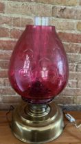 A brass and cranberry glass oil lamp, Improved Venus safety lamp with an electric conversion, (