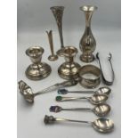 A quantity of hallmarked and sterling silver to include specimen vases, candlesticks, spoons, napkin