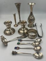 A quantity of hallmarked and sterling silver to include specimen vases, candlesticks, spoons, napkin