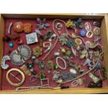 A pine framed table top display case and contents comprising vintage brooches, dress clips, belt