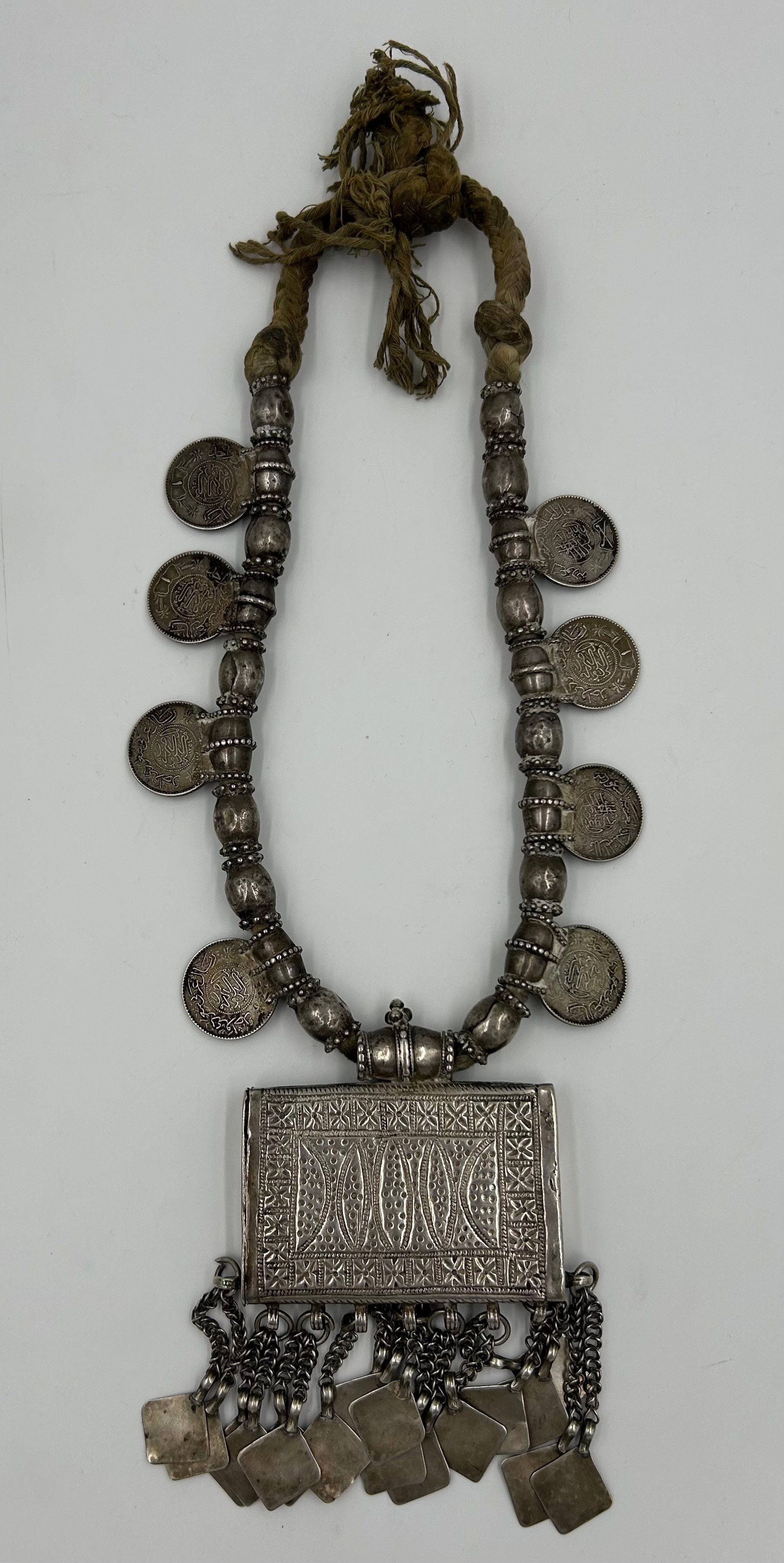 An Omani white metal Hirtz necklace with coin decoration and pendants. 43cm l approx.