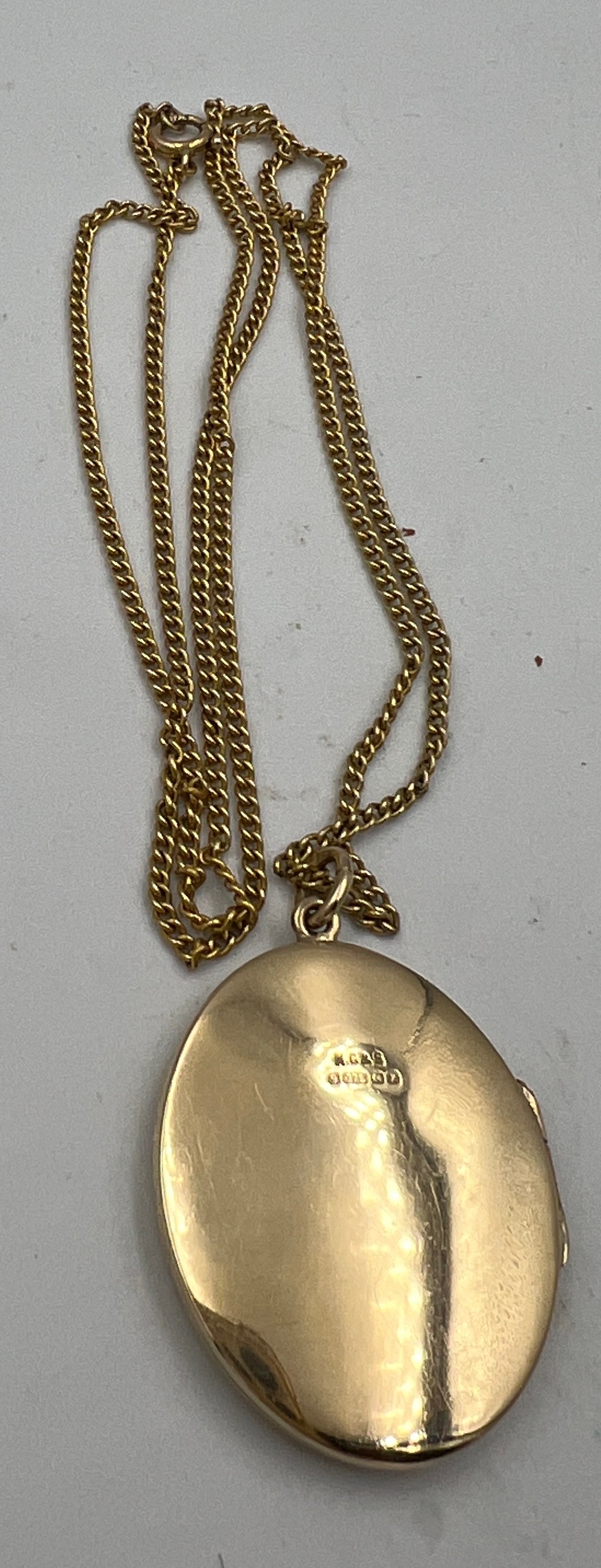 A nine carat gold oval locket and chain. Chain 54cm long. Locket 3cm x 2.5cm approximately. Weight - Image 2 of 3