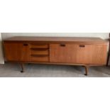 A mid 20thC teak sideboard with three cupboards and three drawers 220cm l x 45cm d x 77cm h.