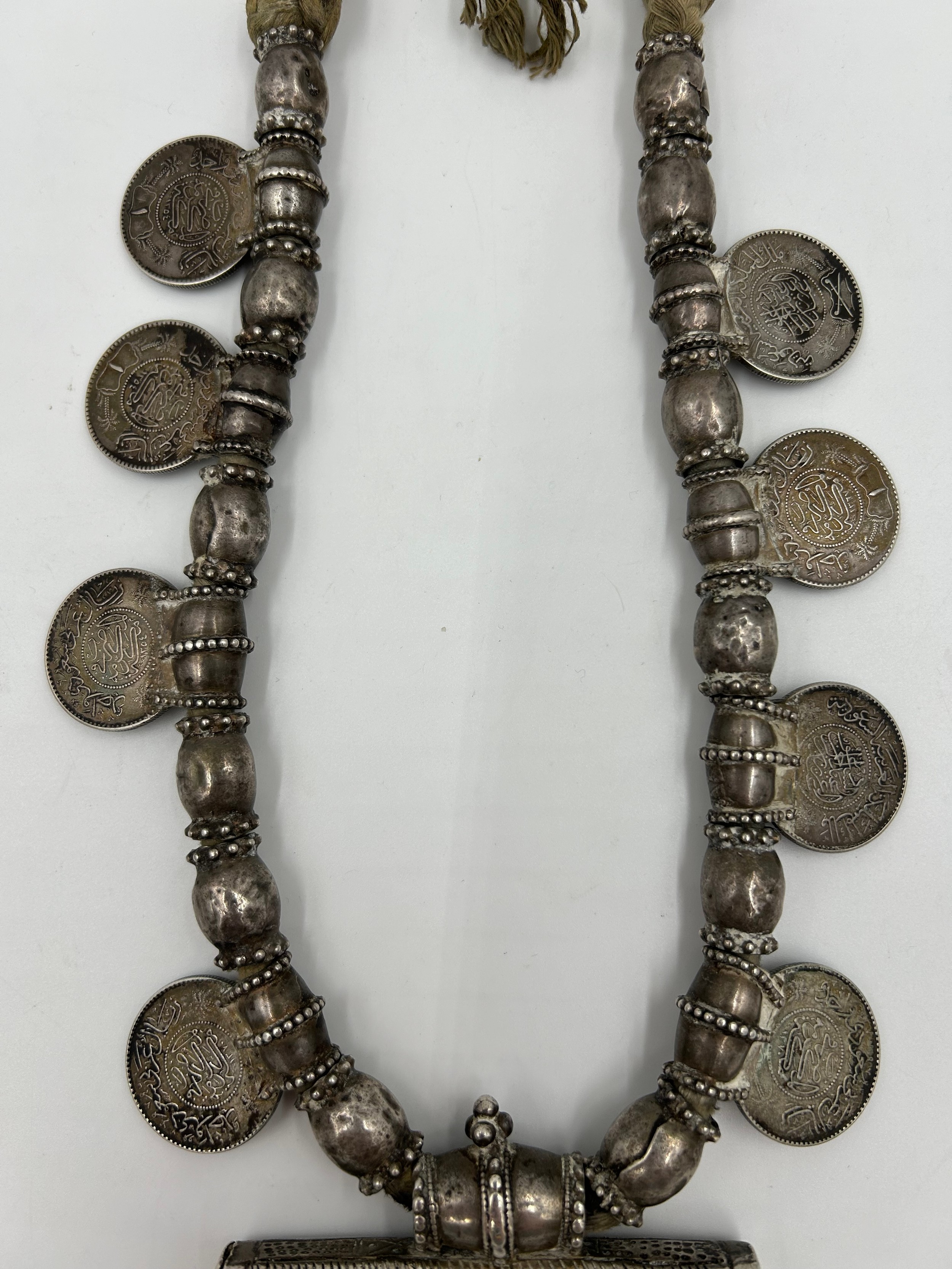 An Omani white metal Hirtz necklace with coin decoration and pendants. 43cm l approx. - Bild 4 aus 7