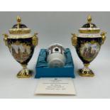 Coalport: Two twin-handled commemorative urn shaped vases with covers and twin goat head handles,