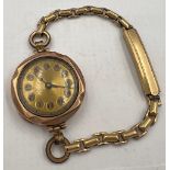 A 9 carat gold cased ladies wristwatch on rolled gold strap. Total weight 19.1gm.