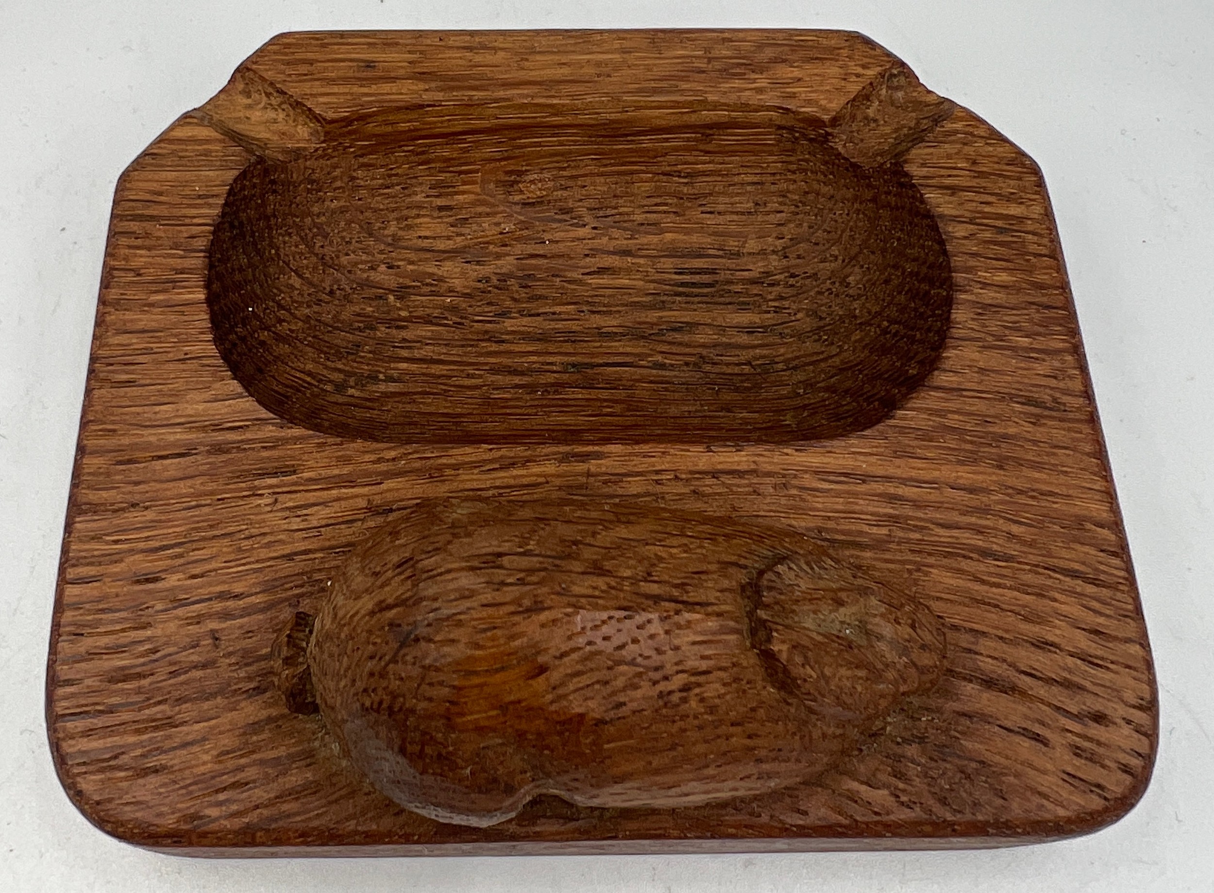 A Peter Heap ‘Rabbitman’ oak ashtray. 10cm x 8.5cm. Marked to underside N with tree.