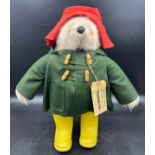 A Gabrielle designs vintage Paddington Bear with dark green duffel coat and yellow Dunlop