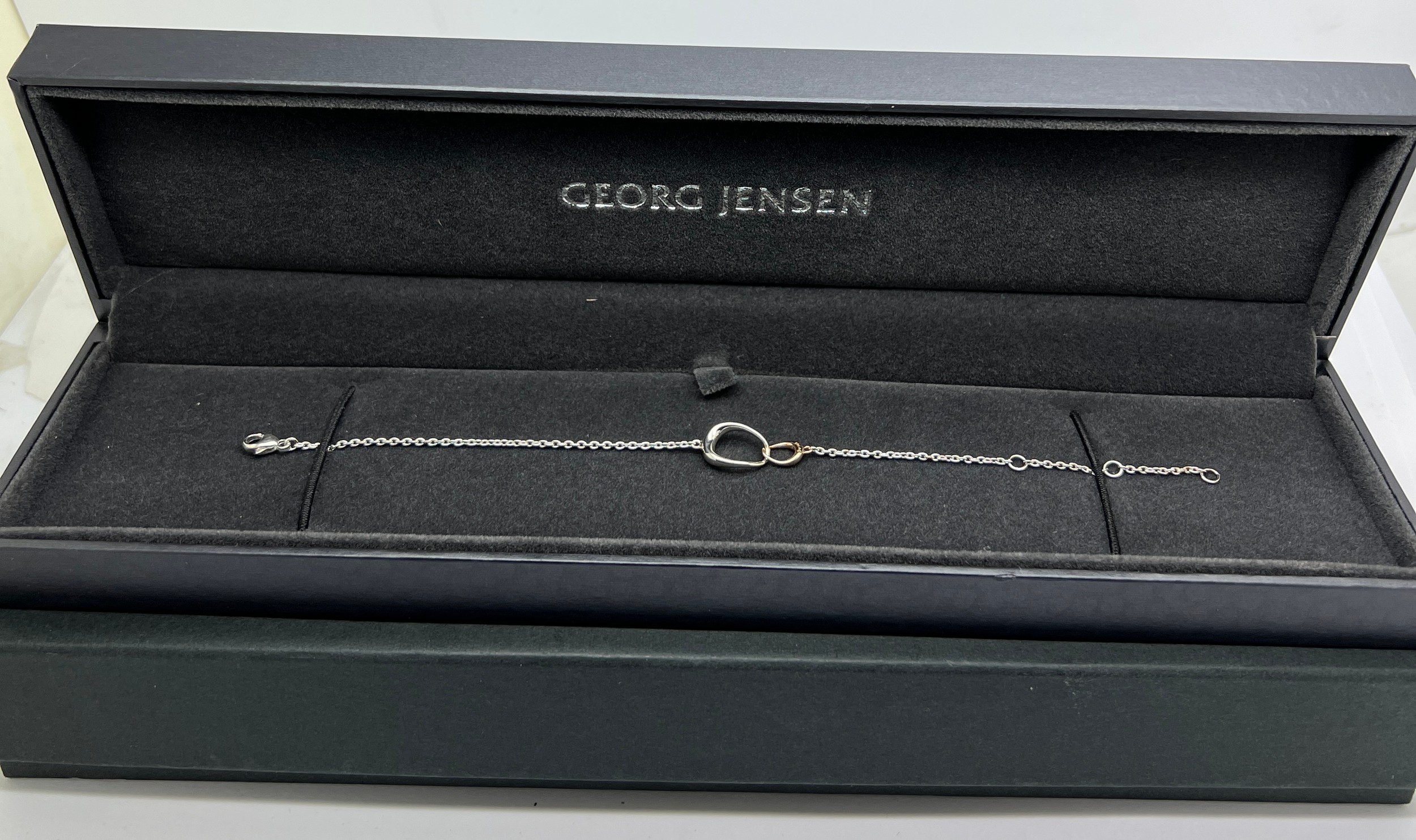 A boxed Georg Jensen Offspring .925 silver and .750 gold bracelet in original presentation box.