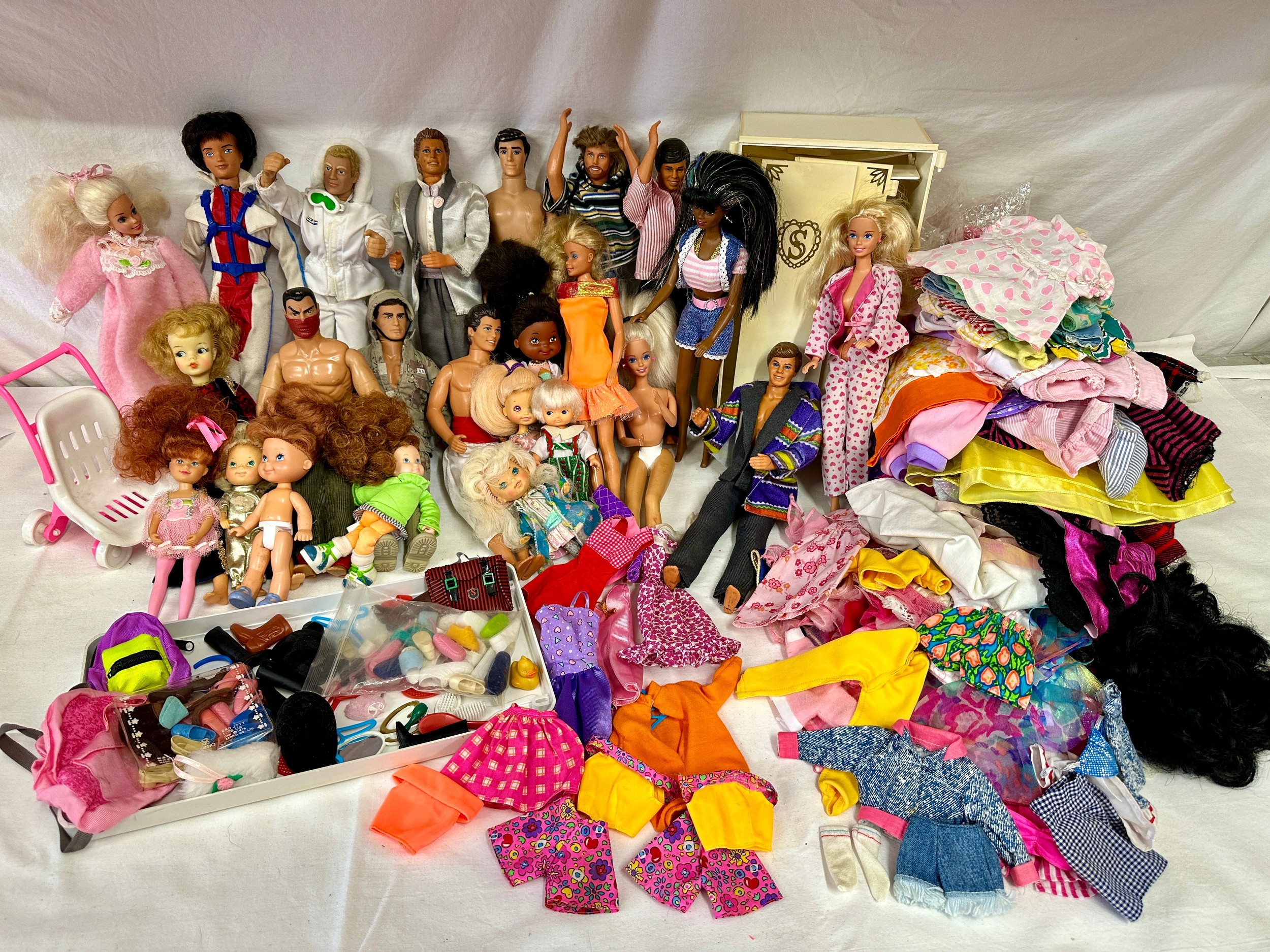 A mixed collection comprising of Barbies, Ken's and GI Joe along with some original Barbie clothes