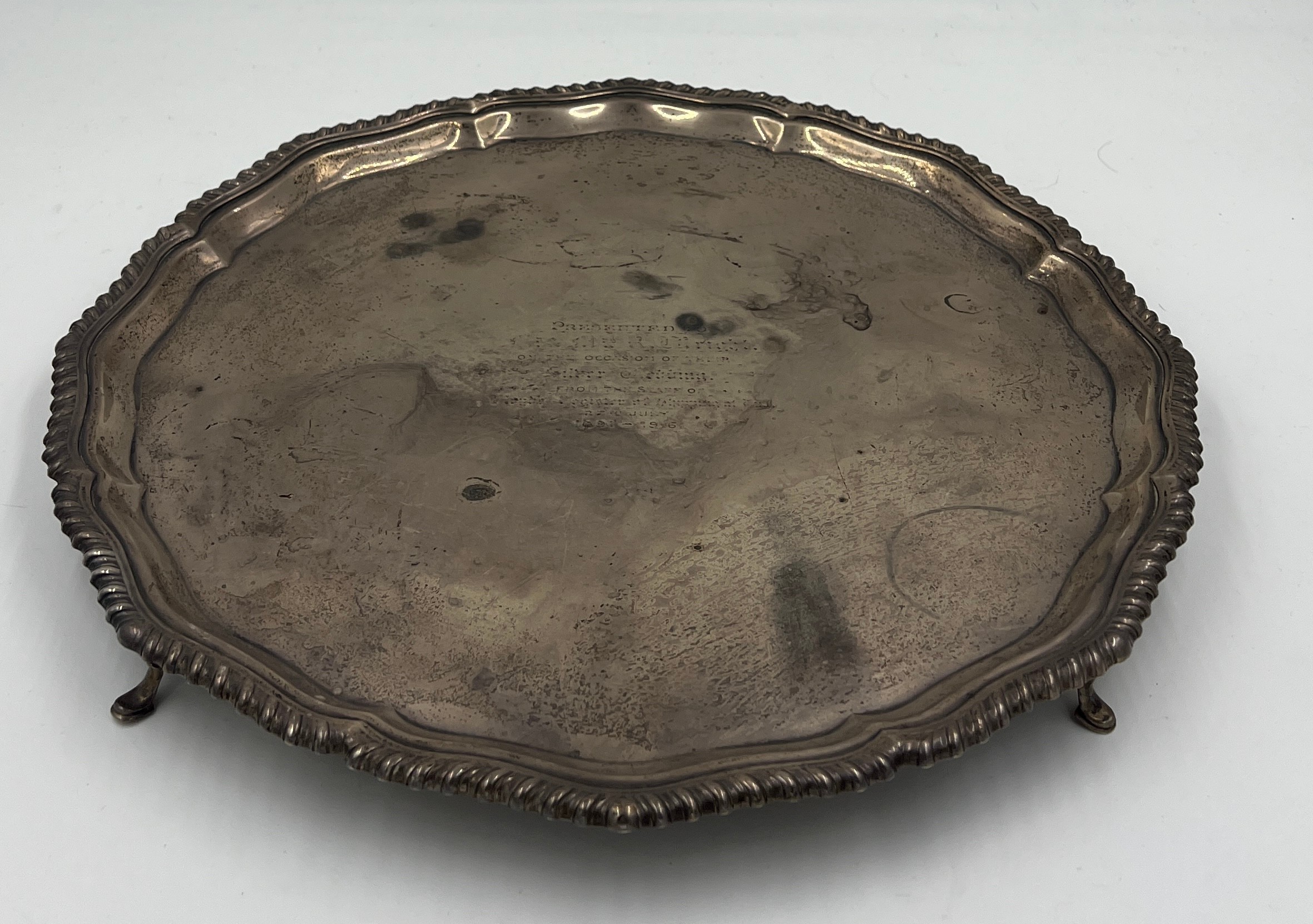 A hallmarked silver tray with gadrooned edge raised on four feet. Weight 880gm. 37cm diameter.