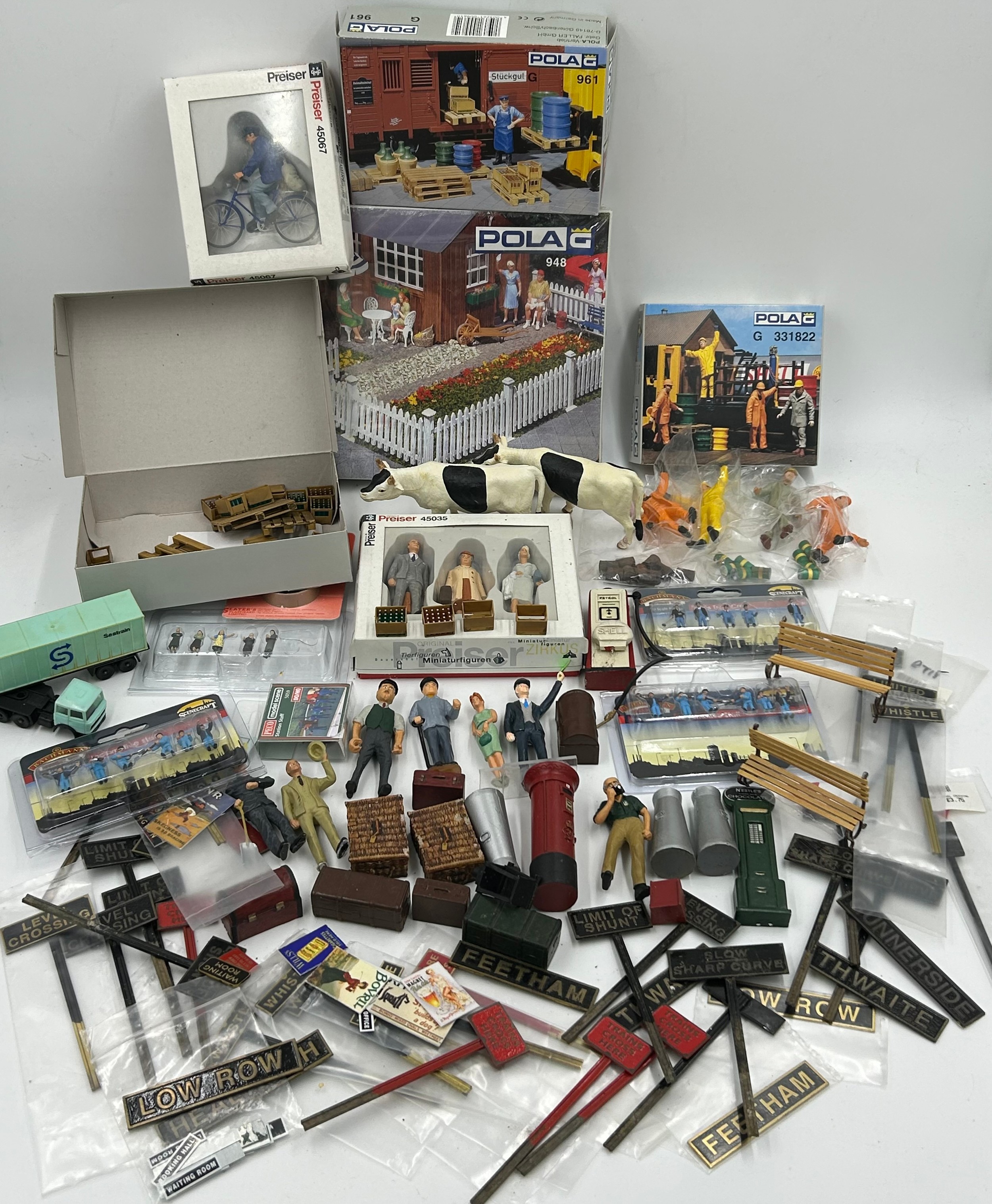 A collection of various miniature railway accessories to include model train metal railway signs,