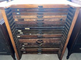 An oak printers chest with 20 drawers and multiple printing blocks. Labelled T.C Thompson & Son Ltd.