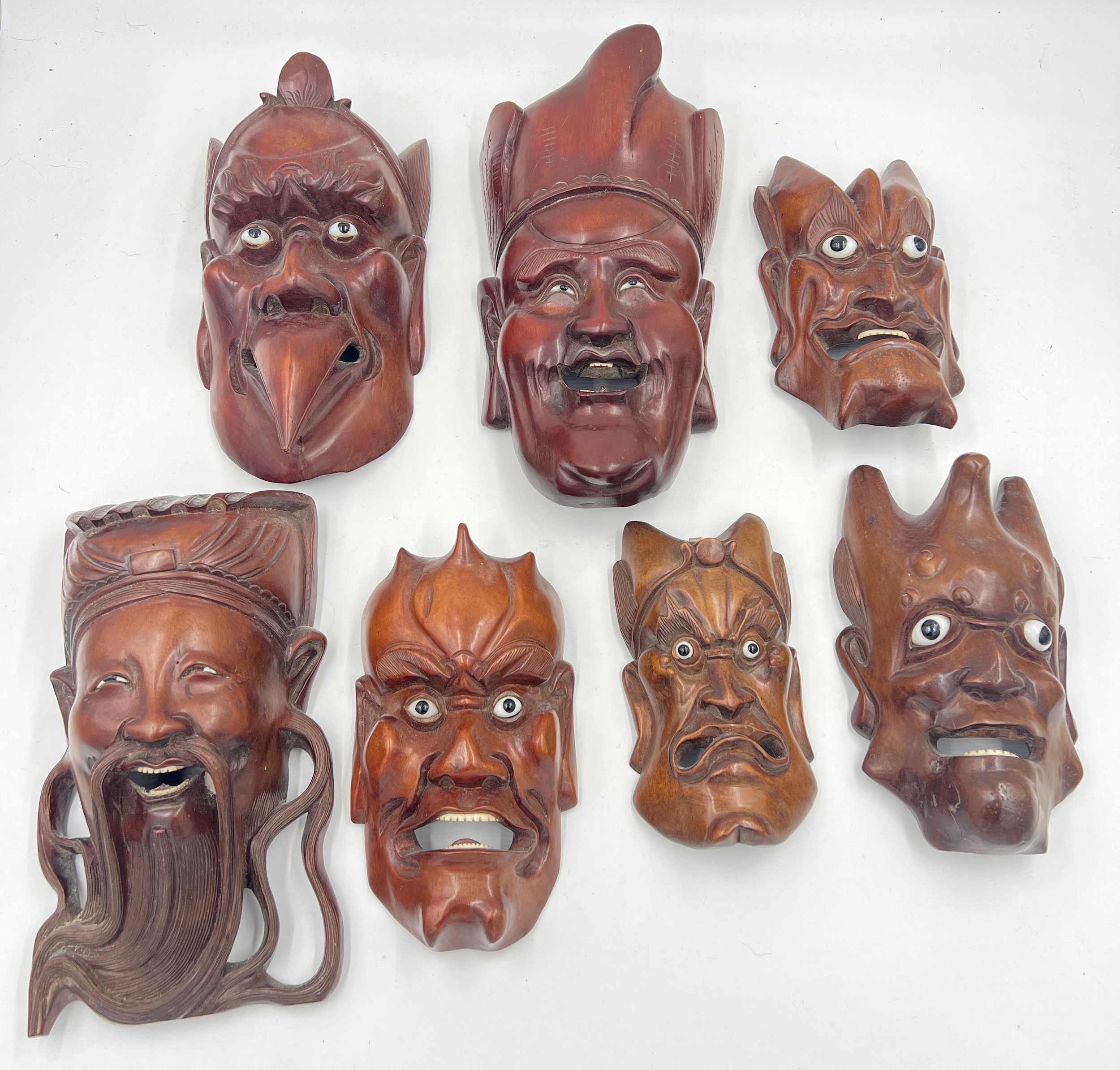 Seven various oriental hardwood masks. Largest 29cm l.