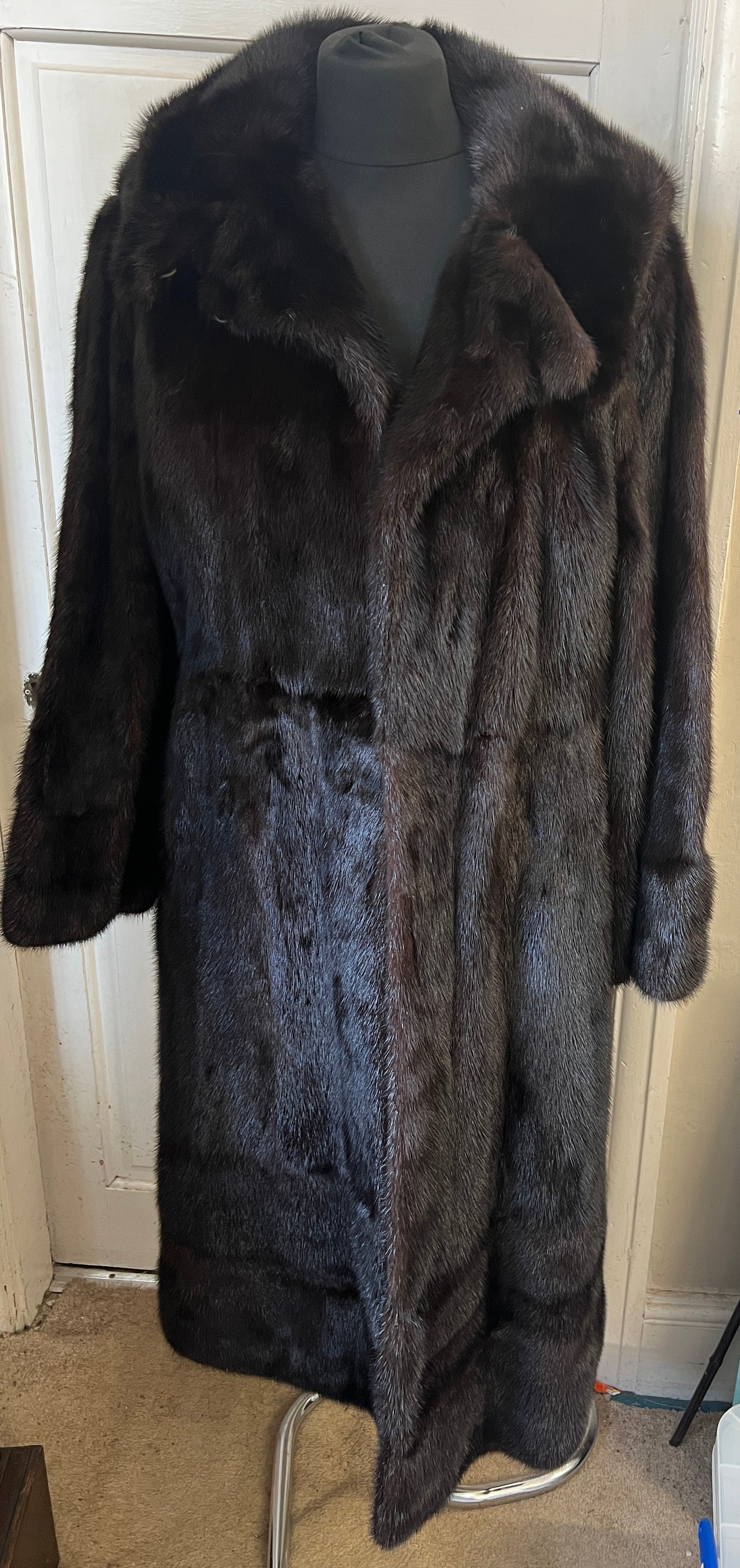 A dark brown long mink coat together with two dark brown mink cuffs.