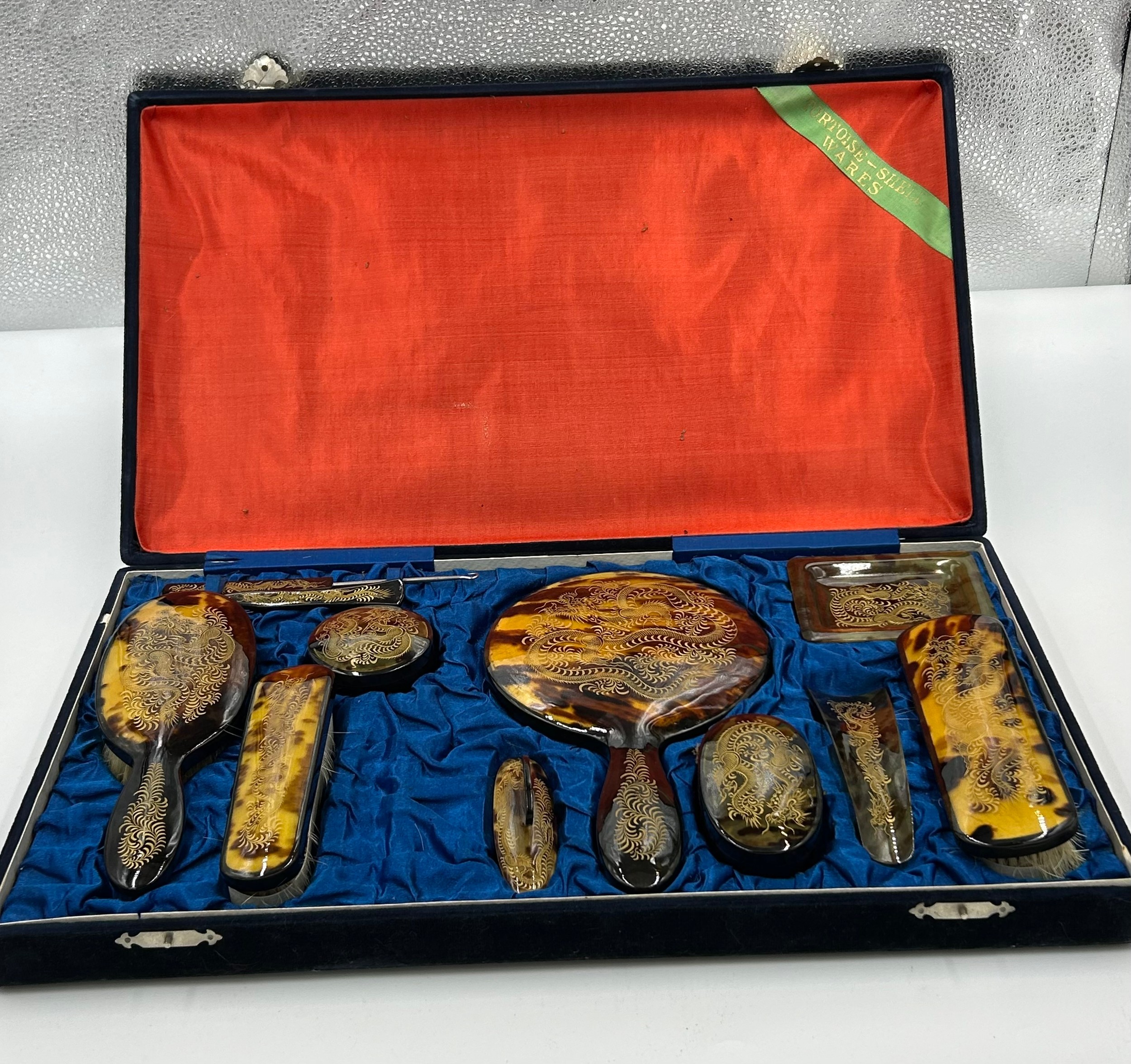 A Faux tortoiseshell 20thC vanity set with gold engraved dragon decoration in original silk lined